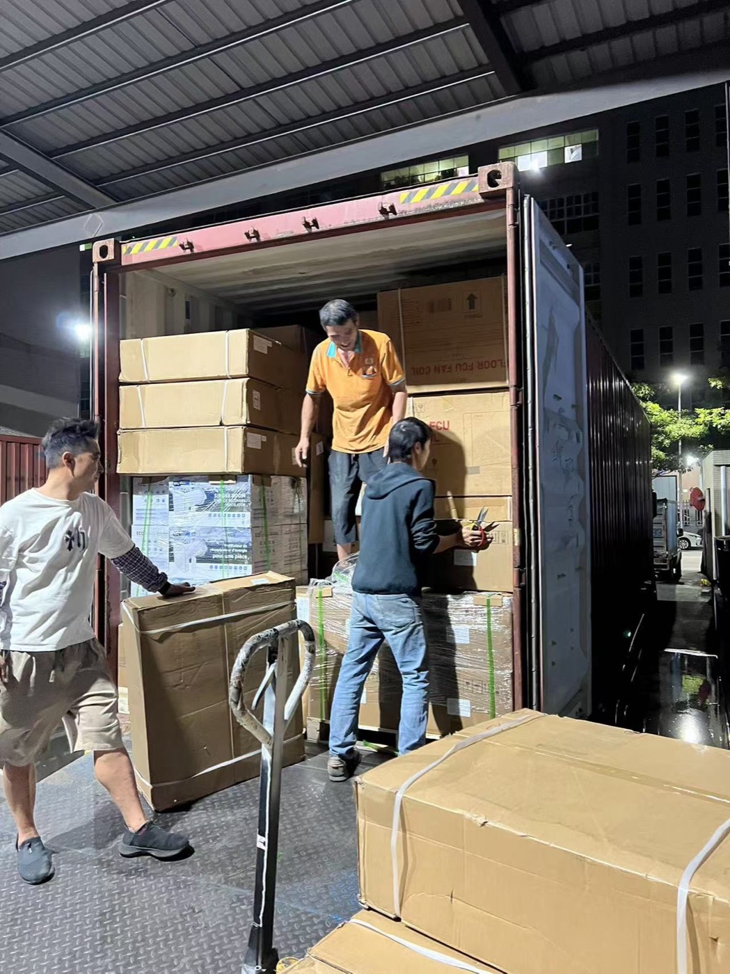 Workers loading cartons into a container